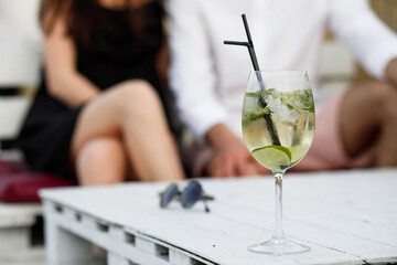 couple seating on the beach bar and drink cocktails. couple drink cocktails