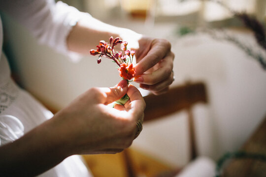 Bridesmaid makes floral arrangements on morning of wedding day