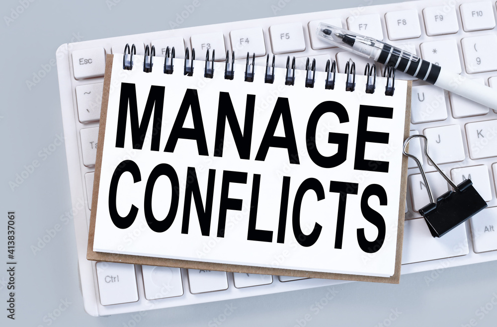 Poster manage conflicts. text on white notepad paper on white keyboard on gray background