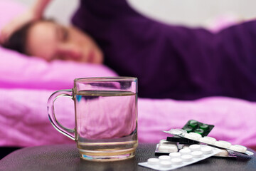 A woman feels sick while lying on the bed.
