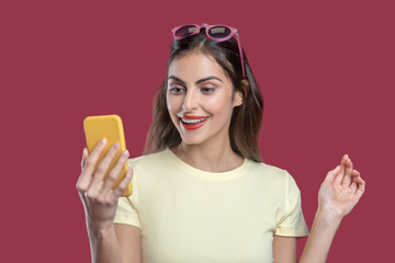 Pretty fashionable young woman looking into smartphone
