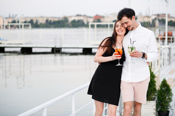 couple seating on the beach bar and drink cocktails. couple drink cocktails