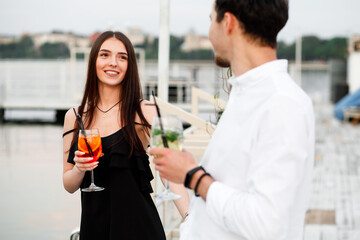 couple seating on the beach bar and drink cocktails. couple drink cocktails