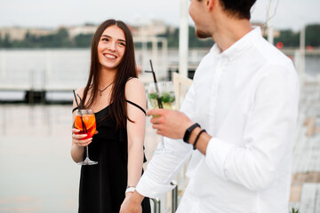 couple seating on the beach bar and drink cocktails. couple drink cocktails
