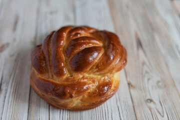 Loaf of homemade wicker white bread on a wooden background, close-up.
