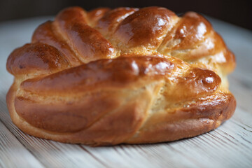 Loaf of homemade wicker white bread on a wooden background, close-up.