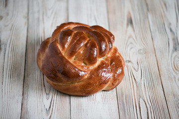Loaf of homemade wicker white bread on a wooden background, close-up.