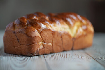 Loaf of homemade wicker white bread on a wooden background, close-up.