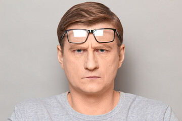 Obraz premium Portrait of serious mature man with glasses on forehead