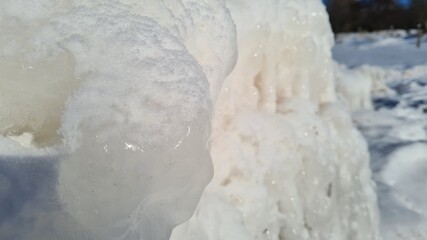Obraz na płótnie Canvas Close-up of ice crystals freezing between rocks on beach
