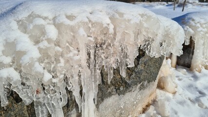 Close-up of ice crystals freezing between rocks on beach