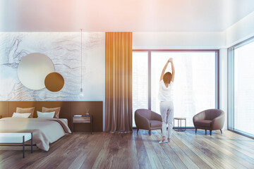 Wooden beige bedroom with armchairs, woman on parquet, lens flare