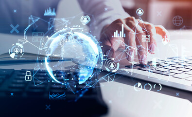 Hands on laptop and calculator with double exposure of earth blue hologram