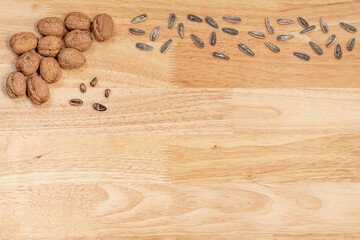 Top view of walnuts, sunflower seeds and pine nuts with copyspace on a wooden table