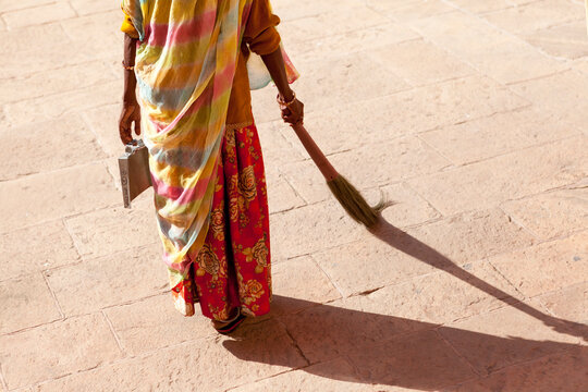 Indian woman sweeper with colorful Sarees sweeping the street