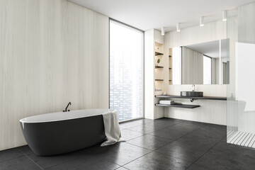 Obraz na płótnie Canvas Black and white bathroom with sink, mirror and black bathtub near window