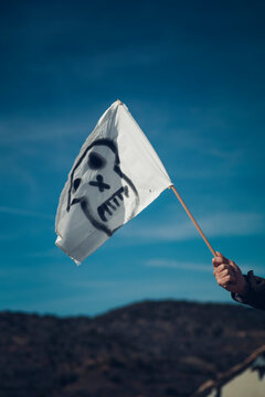 A white flag with a pirate skull drawing.