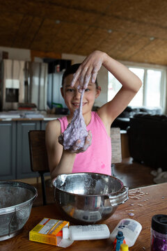 Girl stretching slime she made with her hands