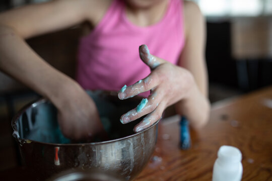 Close up of girl's hands as she makes slime