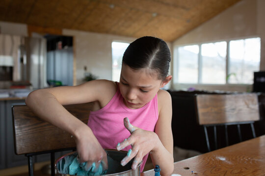 Tween girl mixing slime with her hands