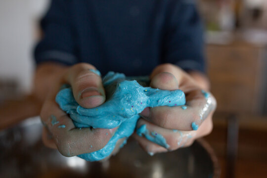 Close up of boy squeezing slime with his hands
