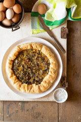Artichoke and speck quiche on a wooden background