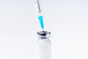 Close up glass vial with flu vaccine and syringe with needle. The concept of vaccination or preventive treatment of injection diseases.
