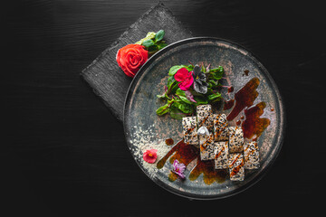 sushi roll with cream cheese, cucumber and eel in plate on black wooden table background