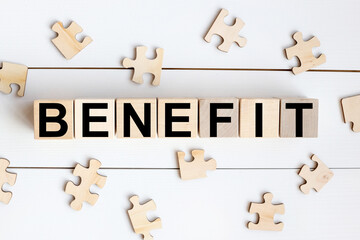 BENEFIT. on wooden cubes on a white background. wood puzzles