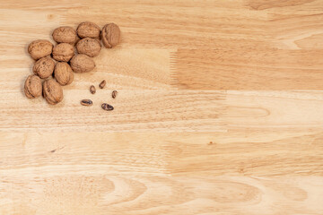 Top view of walnuts and pine nuts with copyspace on a wooden table