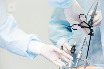 Surgeon performs laparoscopic surgery on the abdomen. Close-up of a laparoscope and doctor's hands - 413848490