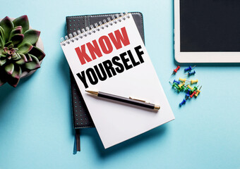 On a light blue background, there is a potted plant, a tablet and a weekly with the text KNOW YOURSELF