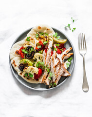 Naan flatbread with grilled roasted vegetables and turkey on a light background, top view. Delicious tapas, appetizers, snack