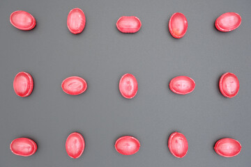 red oval shape shiny caramel barberry candies pattern close-up isolated background top view, sweet...