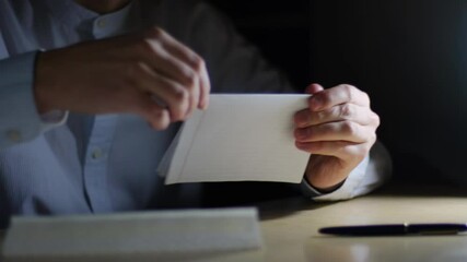 Unrecognizable man packing letter in paper envelope