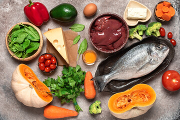 Healthy balanced food background. Foods rich in vitamin A. Turkey liver, vegetables, fresh fish, butter and cheese. Top view, flat lay.