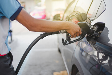 Hand of attendant holding refueling car and pumping at a gas petrol Station