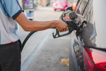 Hand of attendant holding refueling car and pumping at a gas petrol Station