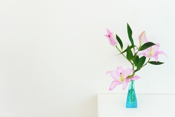 青いガラスの花瓶に生けられたピンクリリー