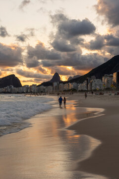Beautiful sunset with clouds and mountains on the shore of Leme Beach