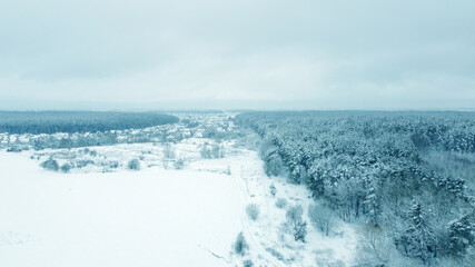 Obraz premium Top view from drone on blue snowy field in winter