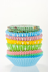 Stack of colorful cupcake cases on white background