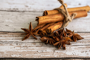 star anise and cinnamon sticks, cinnamon sticks and anise in on rustic wood background 