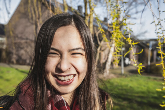 The portrait of smiling mixed race woman on country side in sunny day.