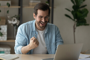 Stroke of luck. Excited young man remote worker get email from ceo about reward for performance of...