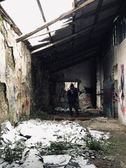  far winter portrait of a man shooting with his camera and wears jacket scarf and camera in a snow abandoned  location 