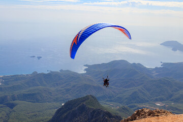 Paragliders flying from a top of Tahtali mountain near Kemer, Antalya Province in Turkey. Concept of active lifestyle and extreme sport adventure