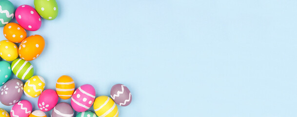 Colorful Easter Egg corner border over a pastel blue paper banner background. Copy space.