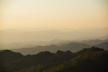 landscape in thailand sunrise on mountains peaceful with mist and sunlight at morning picturesque scenery outdoors travel.