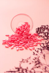 Pink Pearl Hard Wax Beans for depilation background with plant branch.